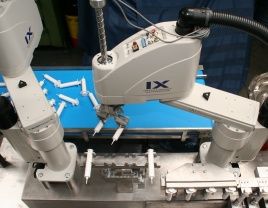 IAI SCARA Robots pakken de injectiespuiten van de band en positioneren ze om gevuld te worden met medicijnen