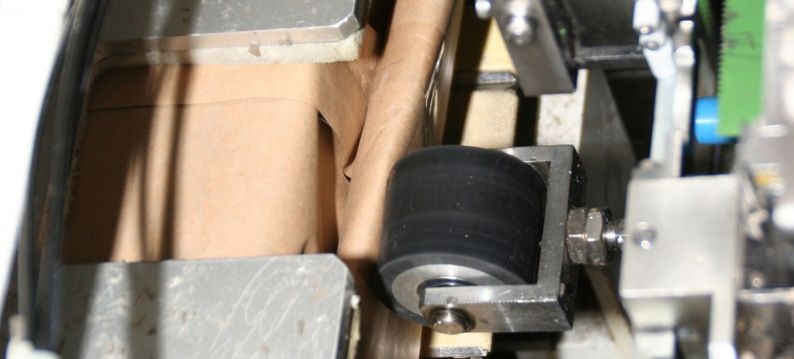 IAI servoactuator moves the roller for taping the packing bottom to top